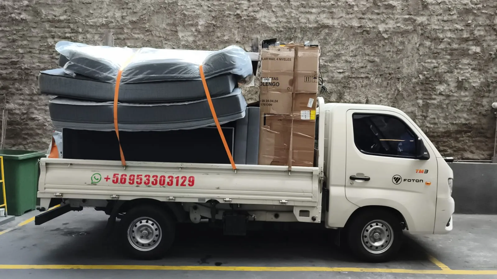 Colchones protegidos con plástico y cajas cargadas en el camión de Fletes Transporte MatCris