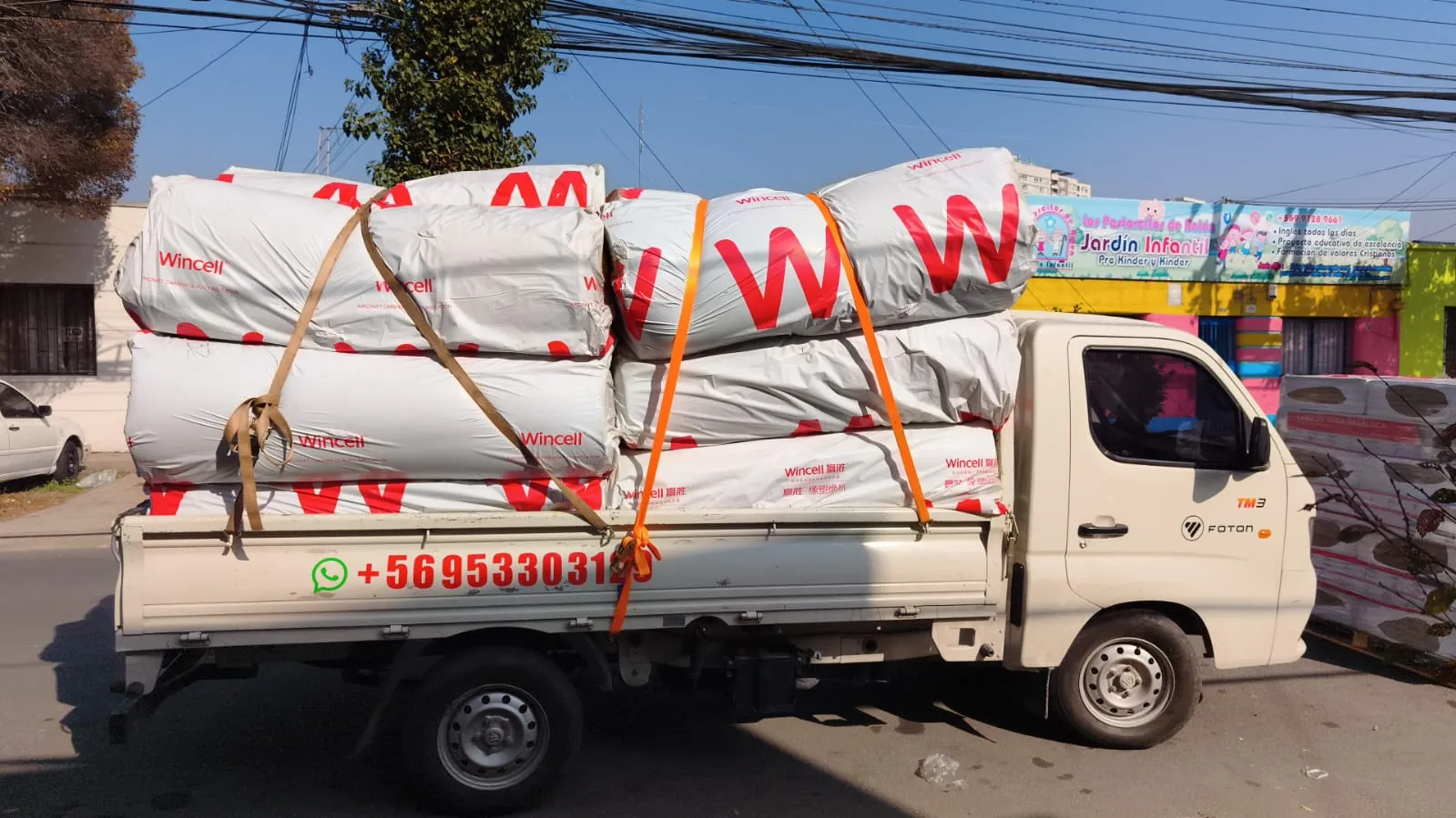 Camión de Fletes Transporte MatCris cargado con rollos de aislación térmica asegurados con fajas